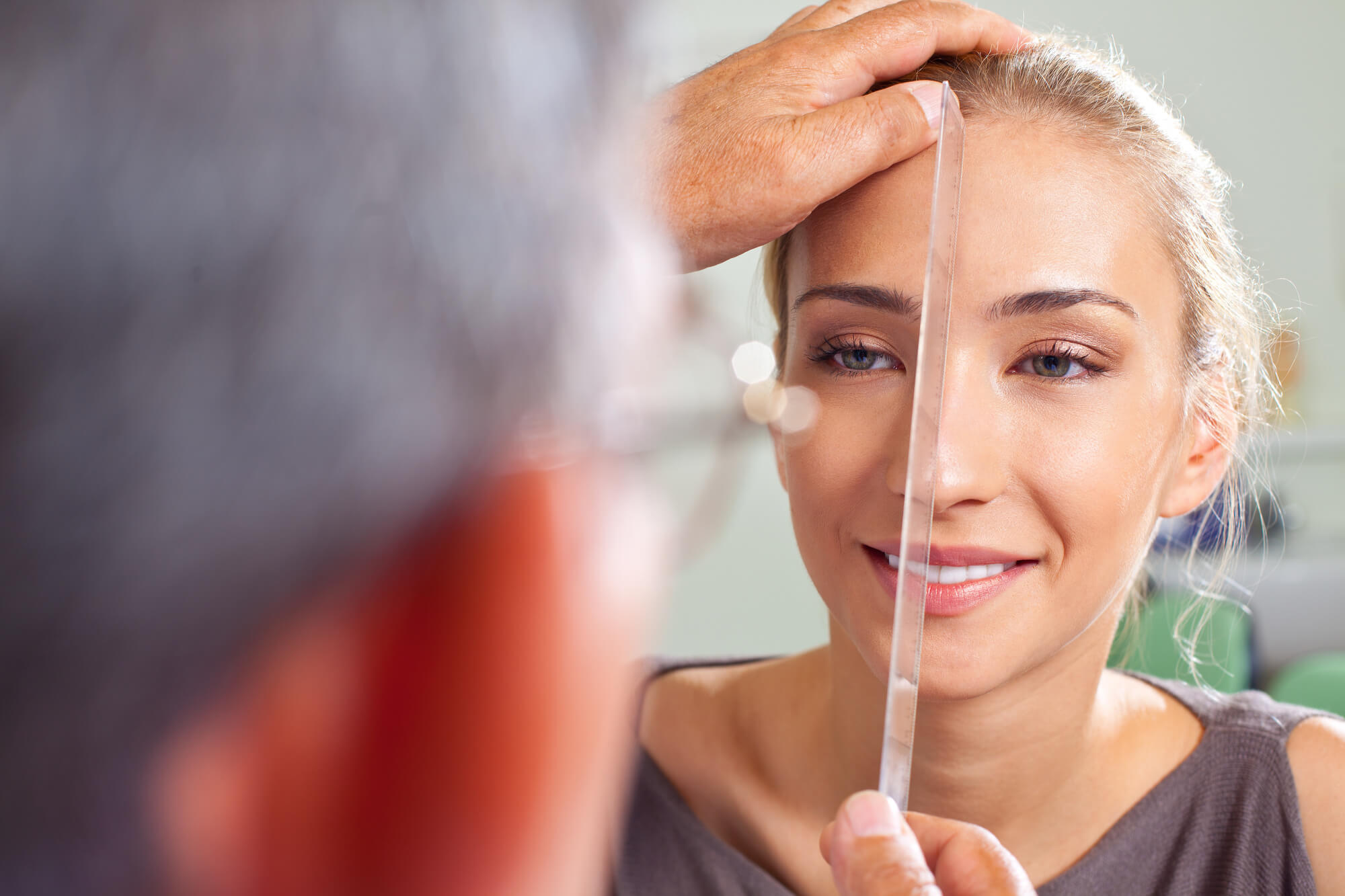 A person measuring a person's face.